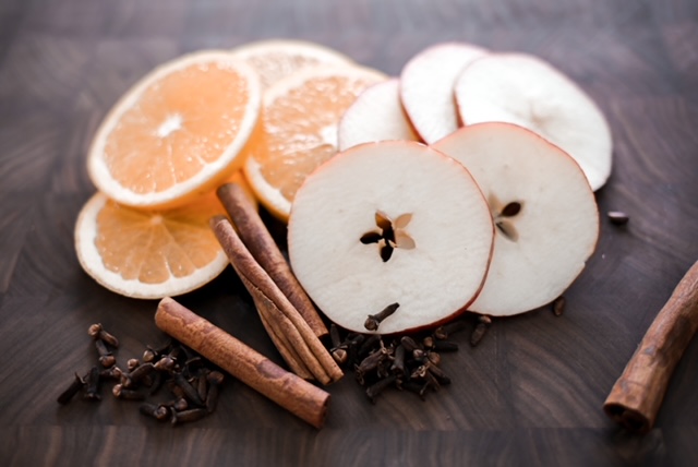 The best fall stovetop potpourri. Apples, oranges, cinnamon sticks and cloves on a cutting board